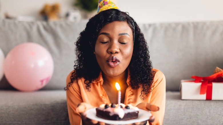 Woman blowing out candle