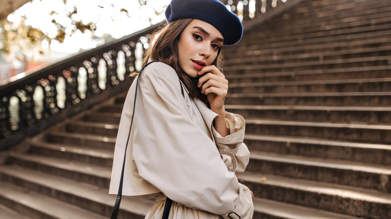 woman wearing a beret and trench coat