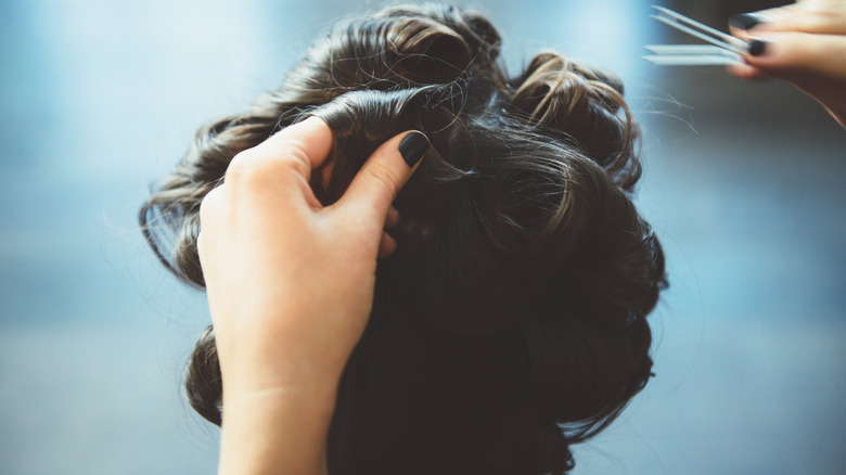 hairstylist making pin curls with prong curl clip