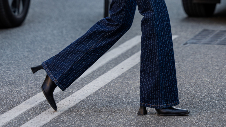 Girl wearing heeled boots with flared jeans.