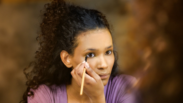 woman applying eyeliner