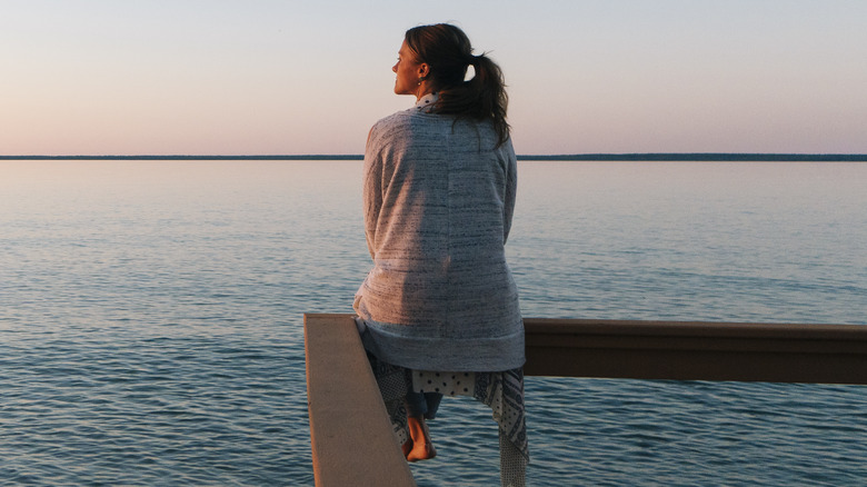 Woman reflecting by the ocean