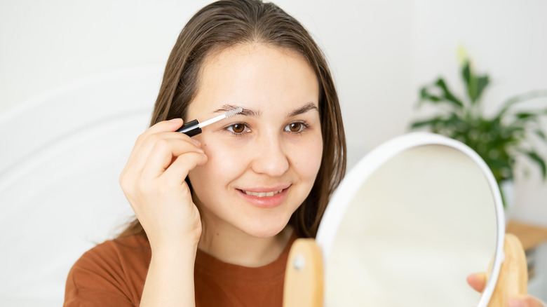 Woman filling in eyebrows