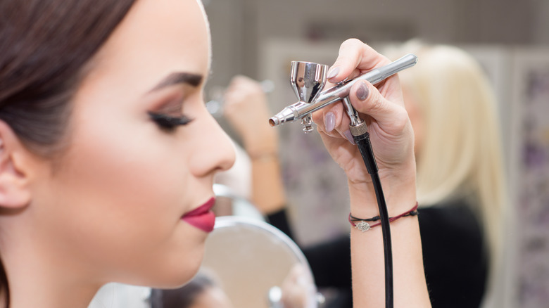 woman getting airbrush makeup