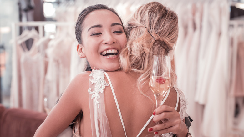 Maid of honor hugging bride