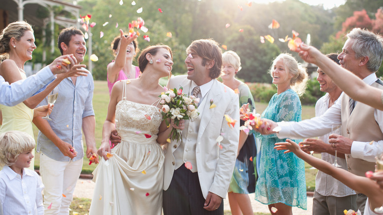 people throwing petals at a bride and groom
