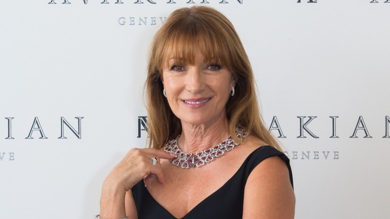 Jane Seymour at a red carpet event wearing a black dress with a statement necklace and dainty earrings.