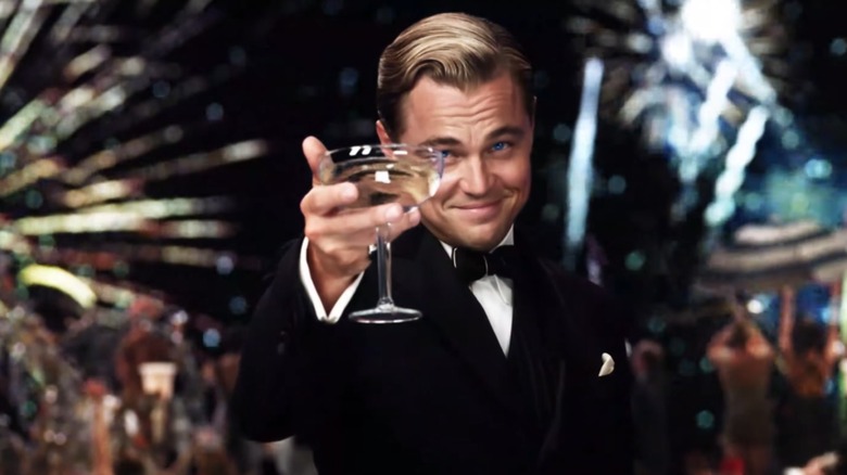 Leo DiCaprio as Gatsby raising a glass