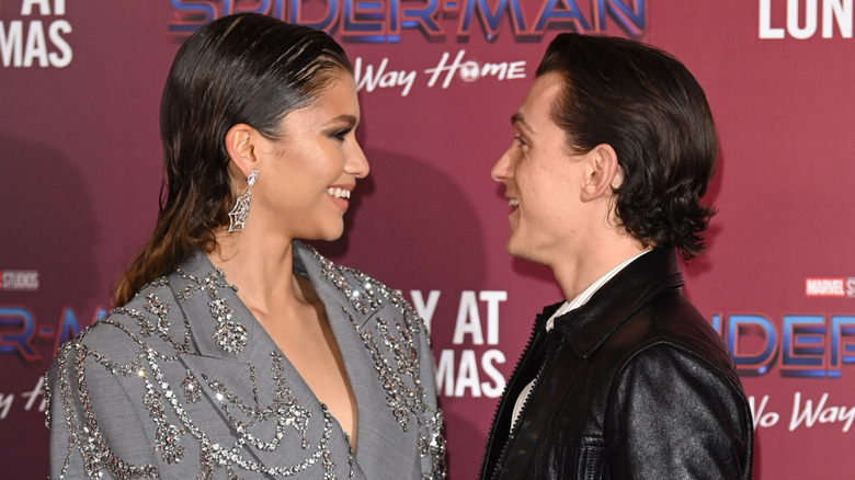 Zendaya and Tom Holland facing each other while on the red carpet