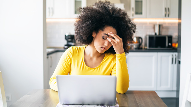 woman looking stressed at laptop