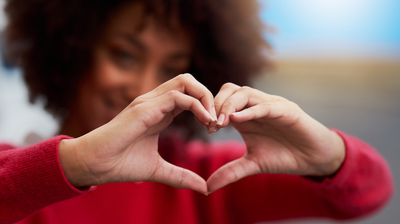 Woman making heart sign hands