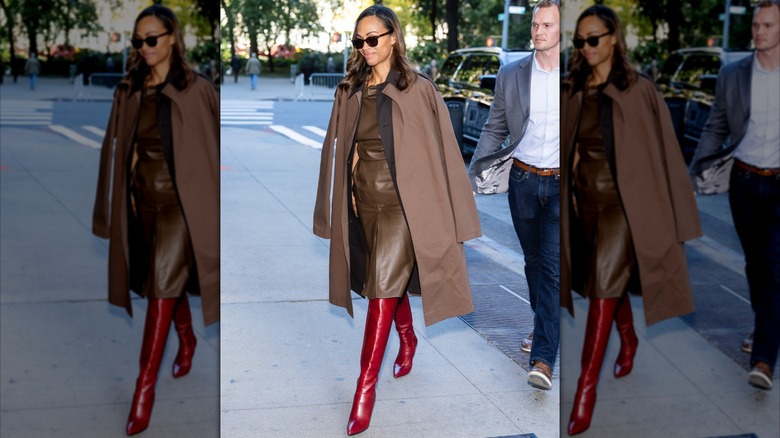 Zoe Saldaña in New York City wearing a brown leather dress with a brown coat, sunglasses, and red boots.