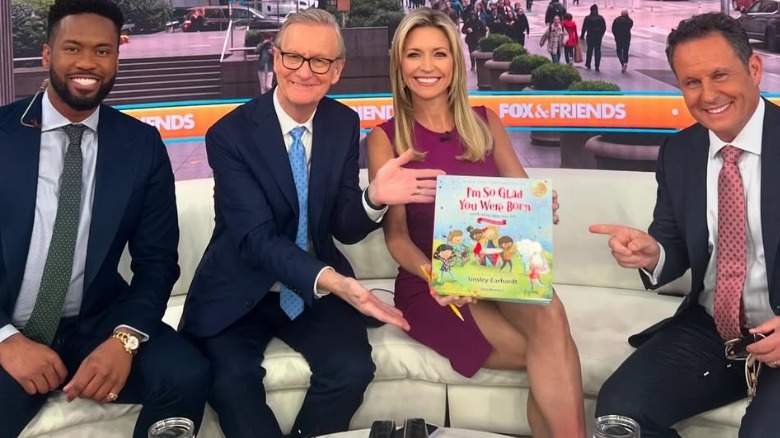 Ainsley Earhardt wearing a short purple dress while promoting a children's book on Fox News