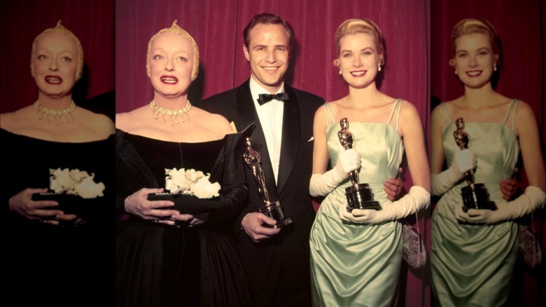 Grace Kelly stands with Marlon Brando and Bette Davis after the 1955 Oscars.