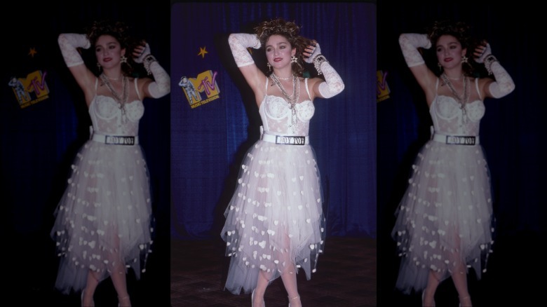 Madonna posing at the MTV Video Music Awards wearing a white lace dress